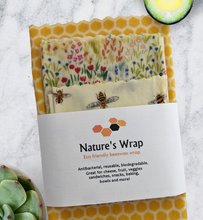 Load image into Gallery viewer, Set of three beeswax wraps banded with a honeycomb logo and suggestions as how to use. Designs are golden honeycomb, field flowers and honey bees reusable beeswax food wraps , best beeswax food wrap sm/md/lg